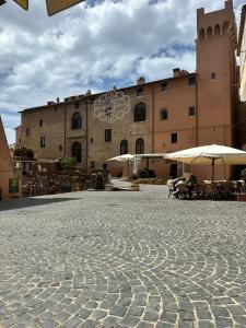 a building with tables and umbrellas in a courtyard at A due passi dal mare 2023 in Nettuno