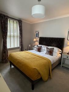 a bedroom with a large bed with a yellow blanket at Number 46 in Hastings