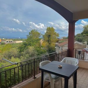 a balcony with a table and chairs and a view at Trinacria Apartment in Monforte San Giorgio Marina