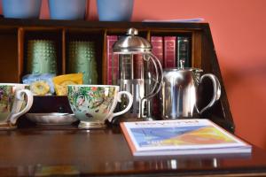a table with two coffee cups and a book at Chez Vivienne in Ilkley