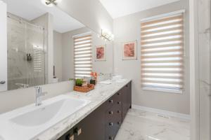 a white bathroom with two sinks and a mirror at Velora Luxe Retreat in Ottawa +22 photos