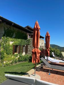 two umbrellas sitting on a patio in front of a house at Luxury Villa Countryside in Bettola +42 photos