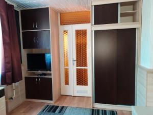 a room with a tv and a door with a television at Fenyves Nyaraló in Hajdúszoboszló