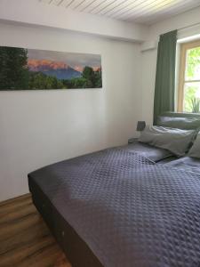 a bedroom with a bed with a painting on the wall at Ferienwohnungen beim Silbergersee in Oberaudorf