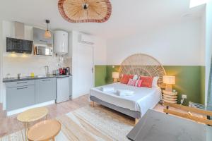 una piccola camera da letto con un letto e una cucina di Iris Parking & Clim - Roanne centre-ville a Roanne