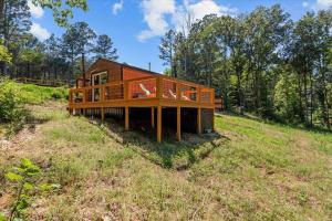 a house in the middle of a field at The Heartwood Hideaway-Charming Cabin Getaway-Trails, Creek, and Starry Nights in Primm Springs
