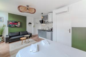 una cucina e un soggiorno con letto e divano di Iris Parking & Clim - Roanne centre-ville a Roanne