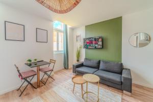 un soggiorno con un divano e un tavolo di Iris Parking & Clim - Roanne centre-ville a Roanne Altre 14 foto