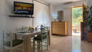 ein Esszimmer mit einem Tisch und einem TV an der Wand in der Unterkunft Apartamento rural Casa Medico in Turre