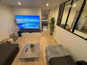 a living room with a large flat screen tv at B0 Appart 2022 - 10min PARIS/EXPO - 5 rooms/6 beds in Bagneux