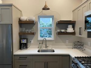 une cuisine avec un évier et une fenêtre dans l'établissement Cozy Modern Cottage, à Ashland 10 autres photos
