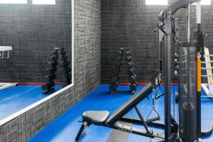 a gym with a row of treadles on a blue floor at Hotel WW in Mérida