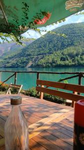 a bottle sitting on a table with a view of a lake at Bujtina Liqeni i Shkopetit in Madhesh +68 photos