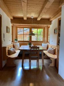 a dining room with a table and a couch at Maiwand in Flintsbach am Inn