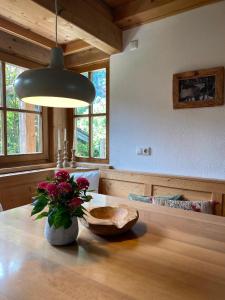 a room with a table with a vase of flowers on it at Maiwand in Flintsbach am Inn +14 photos