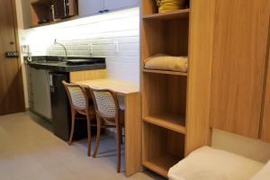 a small kitchen with a table and chairs at ORA Beach Residence by AFT in Porto De Galinhas