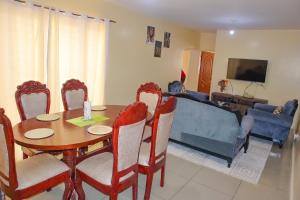 een eetkamer met een tafel, stoelen en een bank bij Kings Square Tebiz Haven in Eldoret