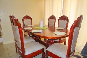 een eettafel met stoelen en een kaars erop bij Kings Square Tebiz Haven in Eldoret