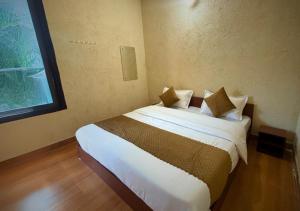a bedroom with a bed with white sheets and pillows at TownHill Homestay in Bhīm Tāl