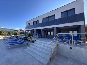 a building with blue chairs and stairs in front of it at Viola Medulin in Medulin