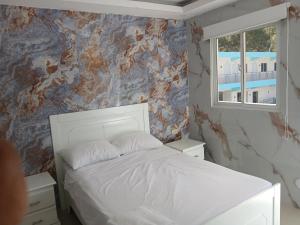 a bedroom with a white bed and a window at Paraíso Vacacional FERNANDO in Polo