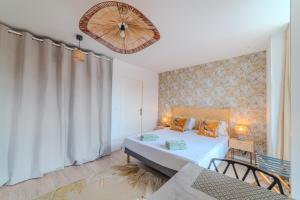 a bedroom with a bed and a chandelier at Mimosa Roanne centre-ville - Parking & Clim in Roanne