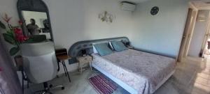 a bedroom with a bed and a desk and a mirror at Studio les pieds dans l'eau in Le Gosier
