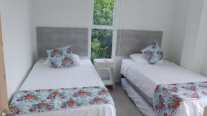 two beds in a room with two windows at Finca Villa Hayde in Flandes