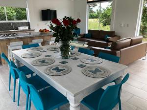 a dining room with a table and blue chairs at Finca Villa Hayde in Flandes