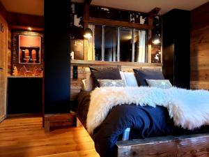 a bedroom with a large bed with a white blanket at Suite Balneo Les Boutons d'or Font Romeu in Font-Romeu