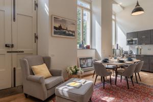 ルッカにあるVerdi Apartmentのテーブルと椅子のあるキッチンとリビングルーム