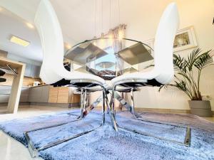 a glass table with two white chairs on a rug at Trave Resort Ferienhaus in Schackendorf