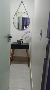 einen Tisch mit einem Spiegel und einer Vase darauf in der Unterkunft Recanto De Eli in Brasilia