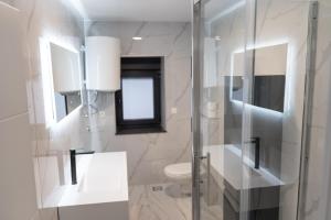 a bathroom with a glass shower and a toilet at Galija in Tomislavgrad +69 photos
