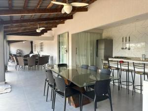 ein Esszimmer und eine Küche mit einem Glastisch und Stühlen in der Unterkunft Recanto De Eli in Brasilia