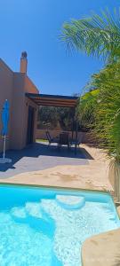 a swimming pool in front of a house at Chania Olive Home in Kato Daratso