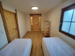 Zimmer mit 2 Betten, einem Fenster und einer Tür in der Unterkunft Unterkunft Wustermark Dorfanger 8 in Wustermark