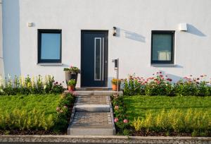 a house with a blue door and some flowers at Sonnensteinzimmer Pirna - zwischen Sächsischer Schweiz und Dresden in Pirna
