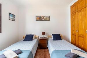two twin beds in a room with a wooden door at Villa Car&Melo in Nazaret +75 photos