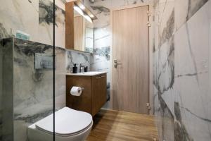 ein Badezimmer mit Toilette und Glasdusche in der Unterkunft Seametry premium residencies Kavala in Kavala + 94 Fotos