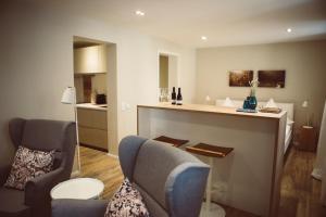 a living room with two chairs and a kitchen at Landers Ferienwohnung in Sankt Martin