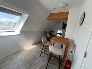 a small room with a table and chairs and a window at Waterzicht 3 in Uitwellingerga