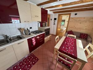 a kitchen with a table and a kitchen with a dining room at Rifugio di Niki in Falcade