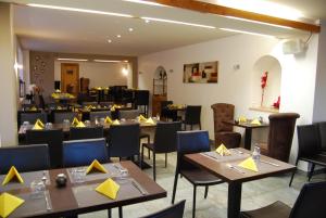 a restaurant with tables and chairs in a room at Auberge de Portout in Chanaz