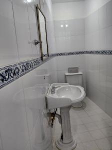 a white bathroom with a sink and a toilet at Casa Marlix in Acapulco +14 photos