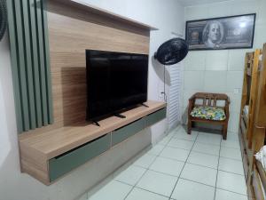a living room with a flat screen tv on a wall at Pousada Charmosa em Guarulhos in Guarulhos
