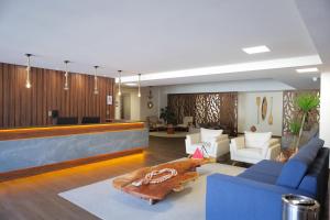 a living room with a blue couch and a table at ORA Beach Residence by AFT in Porto De Galinhas +66 photos