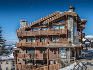 a large wooden house with a deck on a mountain at Grand appartement raffiné et design à Courchevel, 5 chambres, 10 pers., proche remontées mécaniques - FR-1-563-14 in Courchevel
