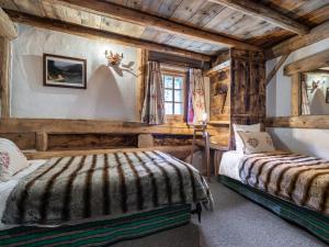 two beds in a room with wooden walls at Chalet 6 chambres avec jacuzzi et sauna, proche télécabine et navette gratuite, Méribel Raffort - FR-1-566-8 in Les Allues