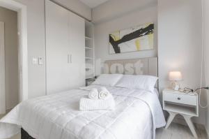 a bedroom with a white bed with two towels on it at Modern Apartment 700m From Shopping Mcal Lopez in Asuncion +19 photos